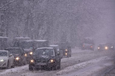 Riga, Letonya. 12 Mart 2019. Caddelerdeki araçlar, kar fırtınası sırasında Riga şehrinde kar yağışı.