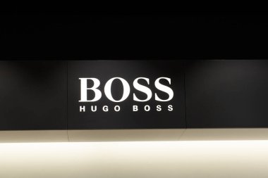 RIGA, LATVIA. 4 Nisan 2019. HUGO patron şirket logosu mağazada. Hugo Boss AG, genellikle BOSS olarak bilinir, merkezi Metzingen 'de bulunan lüks bir Alman moda evi..