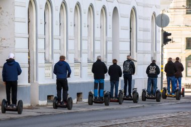 RIGA, LATVIA. 5 Mayıs 2019. Riga şehrinde Segway 'le gezen turistler. Segway, Segway A.Ş. tarafından üretilen iki tekerlekli, kendi kendini dengeleyen bir kişisel taşıyıcı.