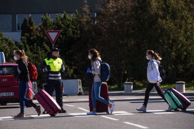 RIGA, LATVIA. 7 Mayıs 2020. Yüz koruyucu maske takan yolcular Riga Uluslararası Havaalanına vardılar..