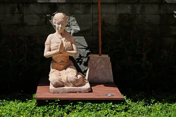 Клэй молится о женской статуе в буддийском храме в Таиланде — стоковое фото