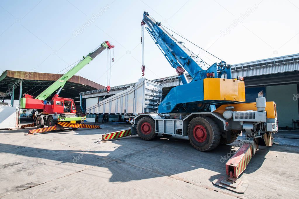 Mobile crane operating by lifting and moving an heavy electric g