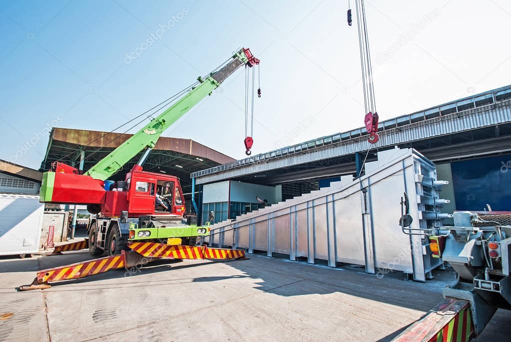 Mobile crane operating by lifting and moving an heavy electric g