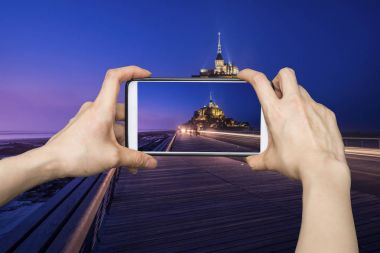 Mobil akıllı telefon Mont Saint-Michel resimleri alarak kız,