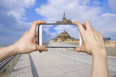Mobil akıllı telefon Mont Saint-Michel resimleri alarak kız,