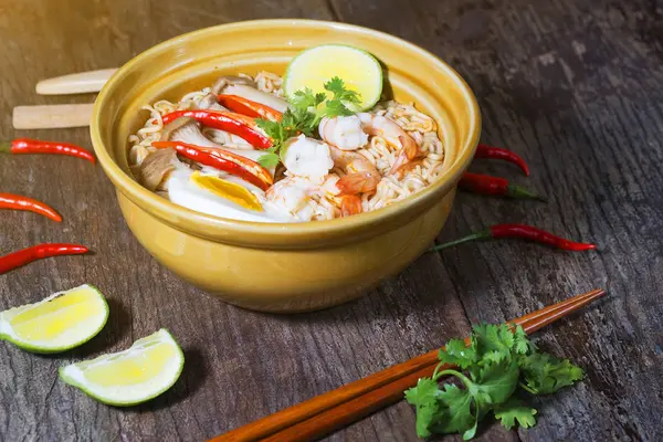 Tay gıda tarzı noodle, tom yum kung ahşap arka plan üzerinde