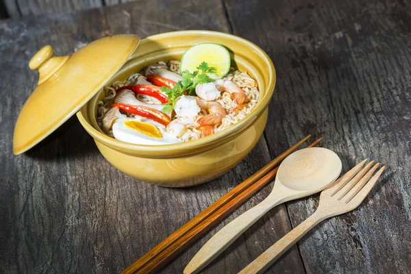 Tay gıda tarzı noodle, tom yum kung ahşap arka plan üzerinde