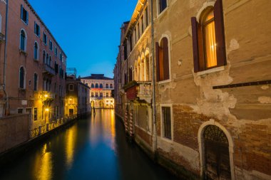 Venedik, alacakaranlıkta su kanalı ve geleneksel renkli evler. ALS