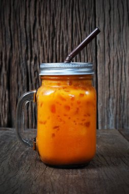 Turuncu Tay buzlu çay ahşap arka plan üzerinde