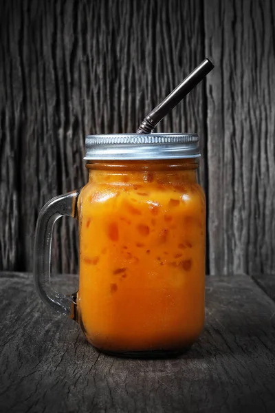 Turuncu Tay buzlu çay ahşap arka plan üzerinde