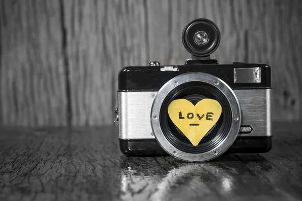 Gamla retro kamera med hjärtat gillar i trä bakgrund — Stockfoto