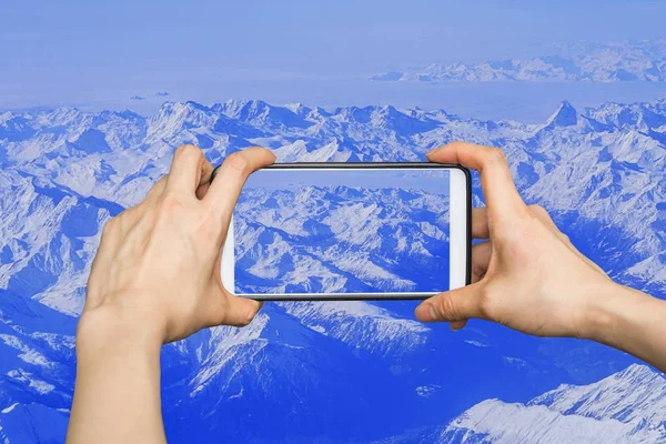 Tomar fotos en el teléfono inteligente móvil en las altas montañas cubiertas — Foto de Stock