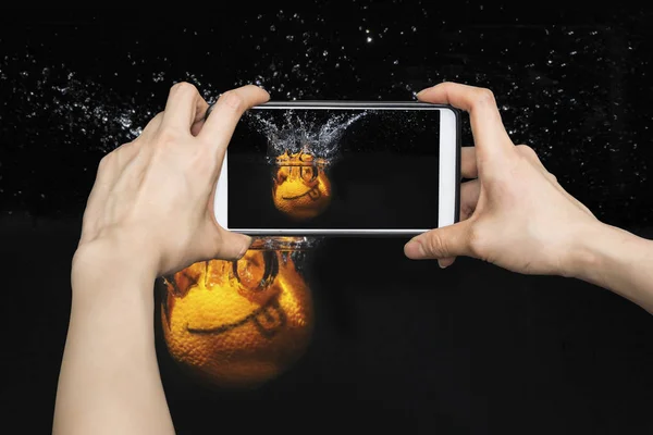 Tomar fotos en el teléfono inteligente móvil Sonrisa naranja con salpicaduras — Foto de Stock
