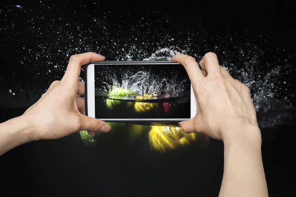 Tomar fotos en el teléfono inteligente móvil en Splashing fruta en wate — Foto de Stock