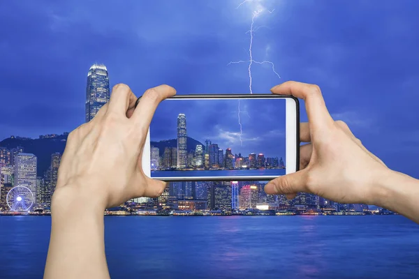 Chica tomando fotos en el teléfono inteligente móvil en Thunderstorm Hong Kong — Foto de Stock
