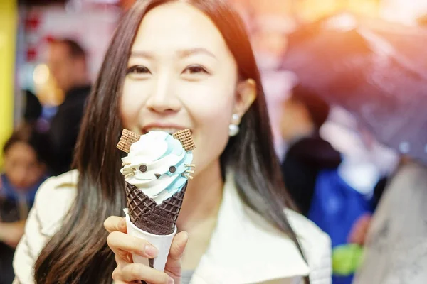 Chinese Asian young female model eating ice cream cone on Hong K