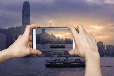 Sunrise Hong Kong'un Victoria Harbour mobil akıllı telefon üzerinde resimleri alarak kız