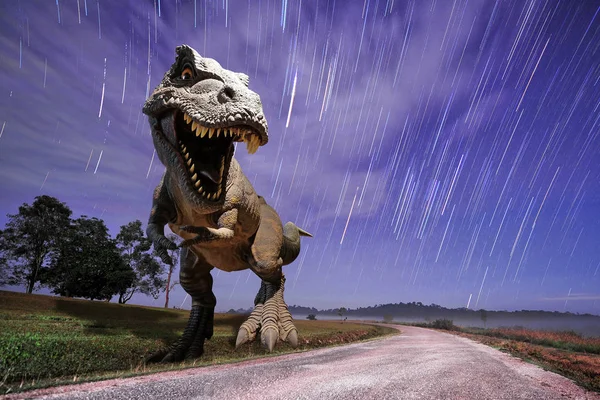 Modelo de dinossauros na queda de estrela no fundo da montanha — Fotografia de Stock