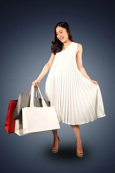 Una donna felice in abito bianco con una shopping bag sul retro biancogr — Foto Stock