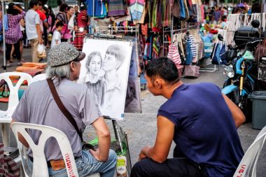 29 Mayıs 2016: sanatçı sokak ressam 29 Mayıs 2016 gece Market street Khonkaen Tayland bir aile portresi çizimi  