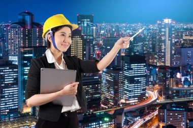 Gece gülümseme dijital tablet tutan genç kadın mühendis 