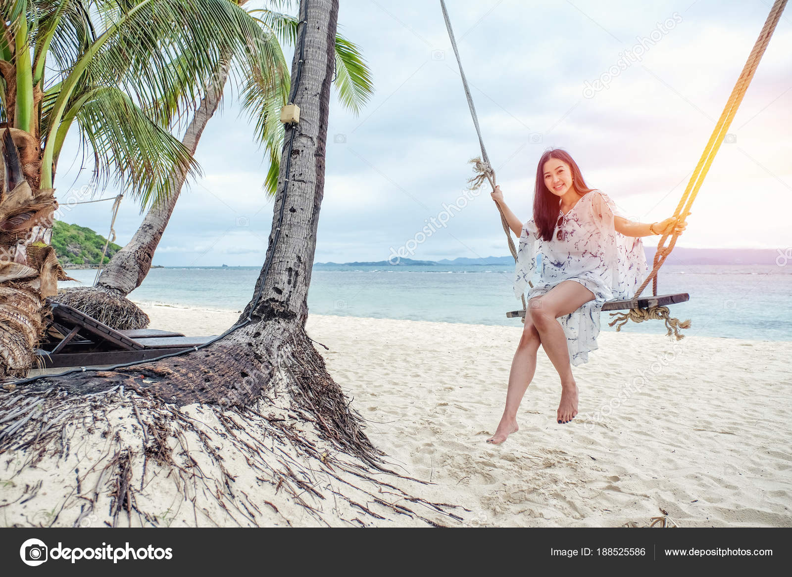 Schöne Frau sitzt auf einer Schaukel am Strand in Koh Phangan