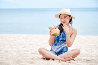 Sahilde taze hindistan cevizi su ile mutlu kadın