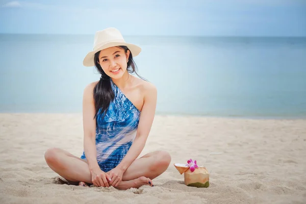Mujer feliz con agua fresca de coco en la playa — Foto de Stock