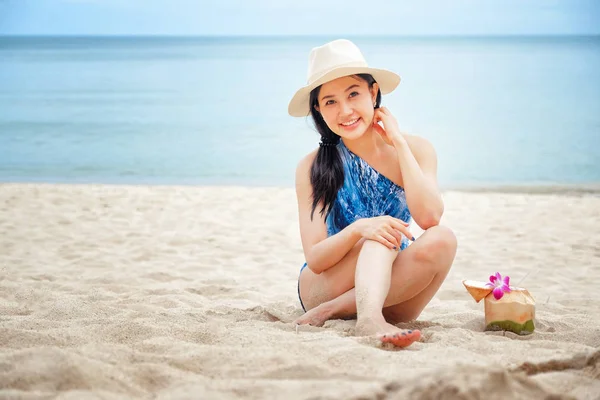Mujer feliz con agua fresca de coco en la playa — Foto de Stock
