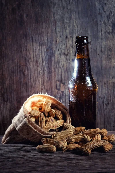 Peanuts and Beer bottle in wood backgroun — Stock Photo, Image