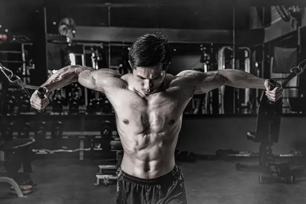 Erős fitness férfi csinál kar edzés kábeles gép a g — Stock Fotó
