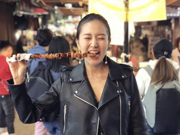 Молодая женщина ест осьминогов на улице Мён Дон. — стоковое фото