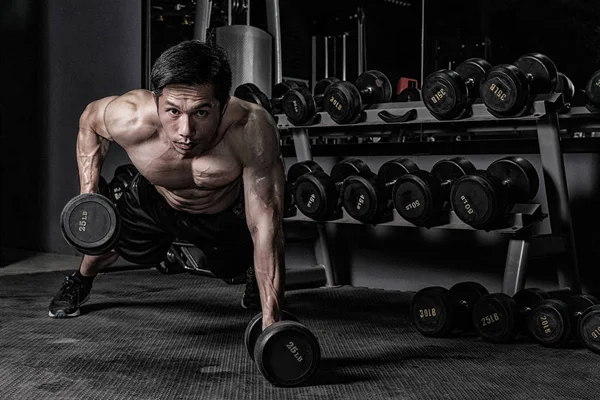 Forte homem de fitness fazendo treino de braço com halteres no ginásio — Fotografia de Stock