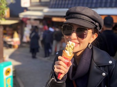 Gerçek altınla kaplanmış dondurma yiyen genç turist kadın.
