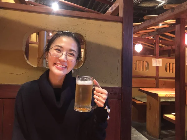 Счастливая улыбающаяся женщина наслаждается пивом в классическом ресторане в Дж. — стоковое фото