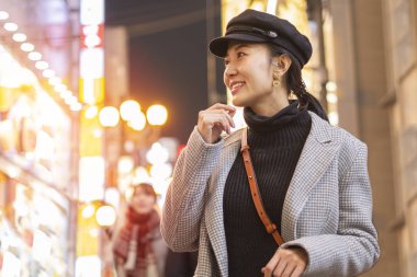 Tokyo, Japonya 'daki Shibuya alışveriş merkezinde yürüyüş yapan güzel gülümseyen kadın turistler..