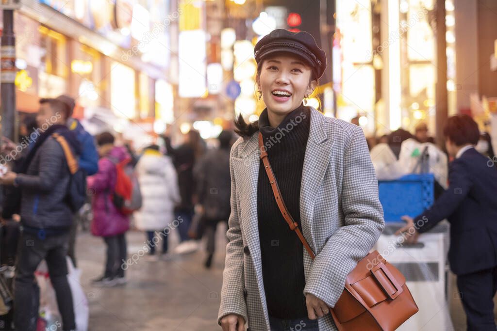 Beautiful smiling woman tourists traveling in walking at street shopping center Shibuya in Tokyo, Japan.