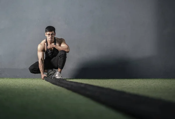 筋力トレーニングフィットネスジムでロープ付きの強力な筋肉マンワークアウト — ストック写真