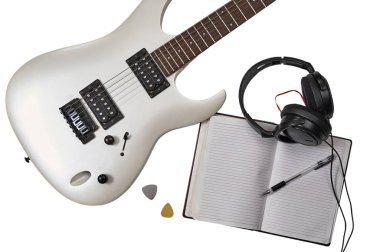 Top view of closeup of white electric guitar, two mediators, open notebook, pen and headphones. Workspace of musician. Isolated on white background with clipping path clipart