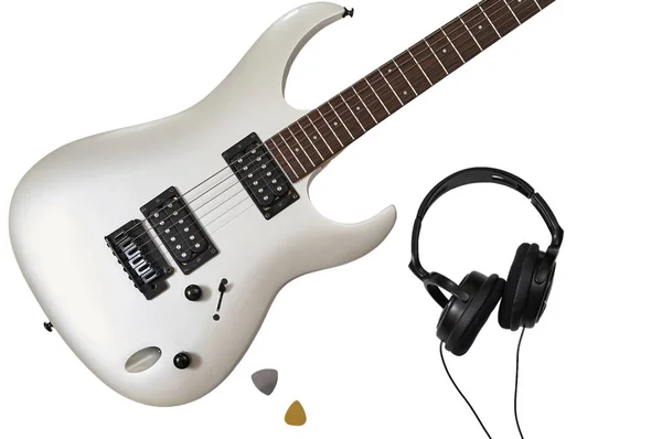 Beyaz elektro gitarın yakın plan görüntüsü, iki arabulucu ve kulaklık. Müzisyenlerin çalışma alanı. Kırpma yolu ile beyaz arkaplanda izole