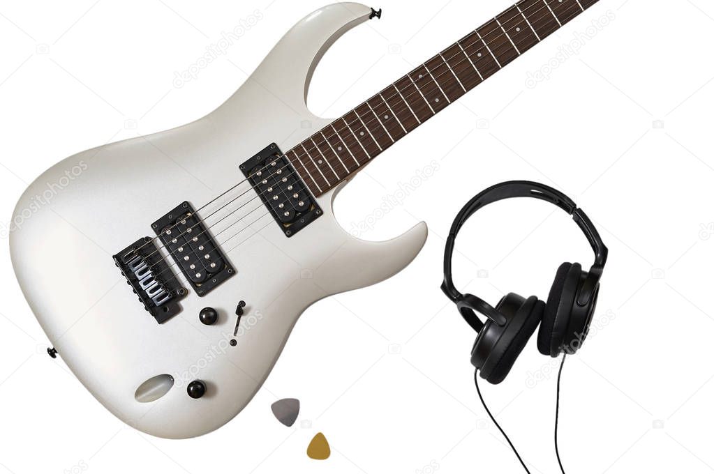 Top view of closeup of white electric guitar, two mediators and headphones. Workspace of musician. Isolated on white background with clipping path