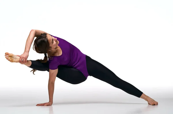 Yoga minderi üzerinde egzersiz yapan çekici bir kadının portresi. Sağlıklı yaşam tarzı ve spor anlayışı. Bir dizi egzersiz pozu. Beyazda izole edilmiş