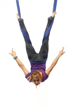 Genç ve güzel bir kadın hamakta yerçekimi karşıtı yoga egzersizleri yapıyor. Beyaz arkaplanda izole