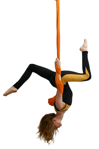 Young woman practices aerial anti-gravity yoga with a hammock in a white studio. Concept of a mental and physical health an harmony living