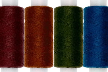 Beyaz arkaplanda nakış işlemek için çok renkli iplikler