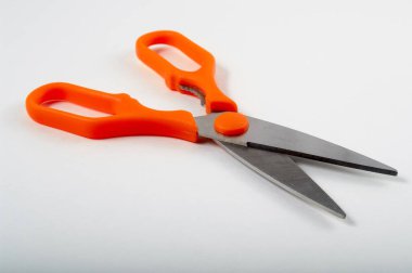 Beyaz arka planda izole edilmiş turuncu plastik saplı modern mutfak makası.