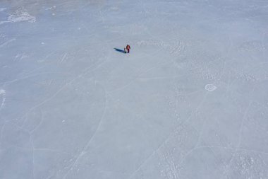 Gölün buzunda iki kişi, büyük bir alanda tek başına.