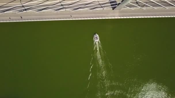 Le bateau passe sous le pont. La voiture se déplace sur le pont .
