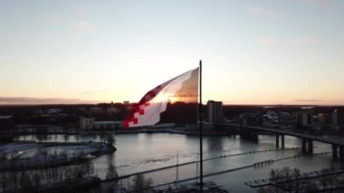 Kuzey Karelya bayrağının havadan görünüşü. Belediye binasının tepesinde bir bayrak. Joensuu, Finlandiya 'da sabahın ilk soğuğunda. Arka planda park ve Pielisjoki Nehri var. Nehrin üzerindeki köprü.