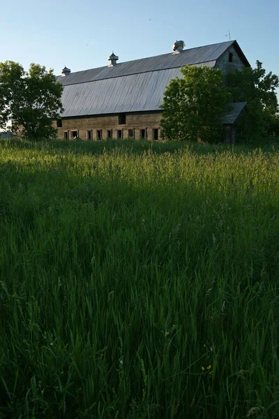 Gräsplan med en gammal lada i bakgrunden — Stockfoto